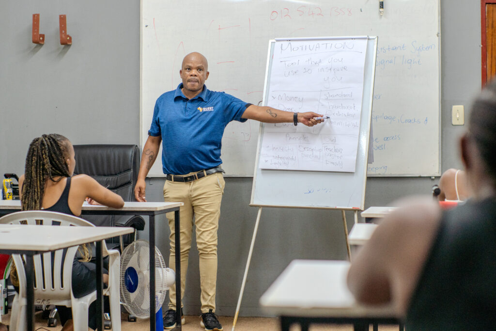 Instructor discussing a motivation chart for workplace skills development in a classroom setting.