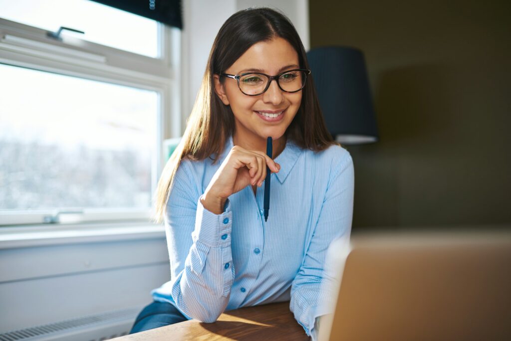 Positive self-employed woman working near window
